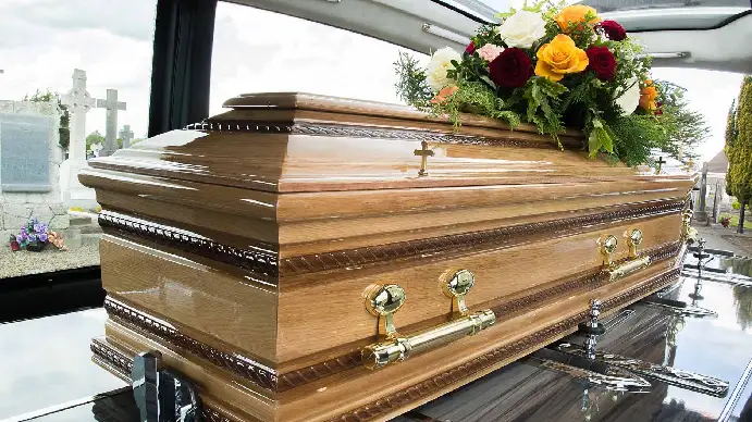 A wooden coffin inside a hearse